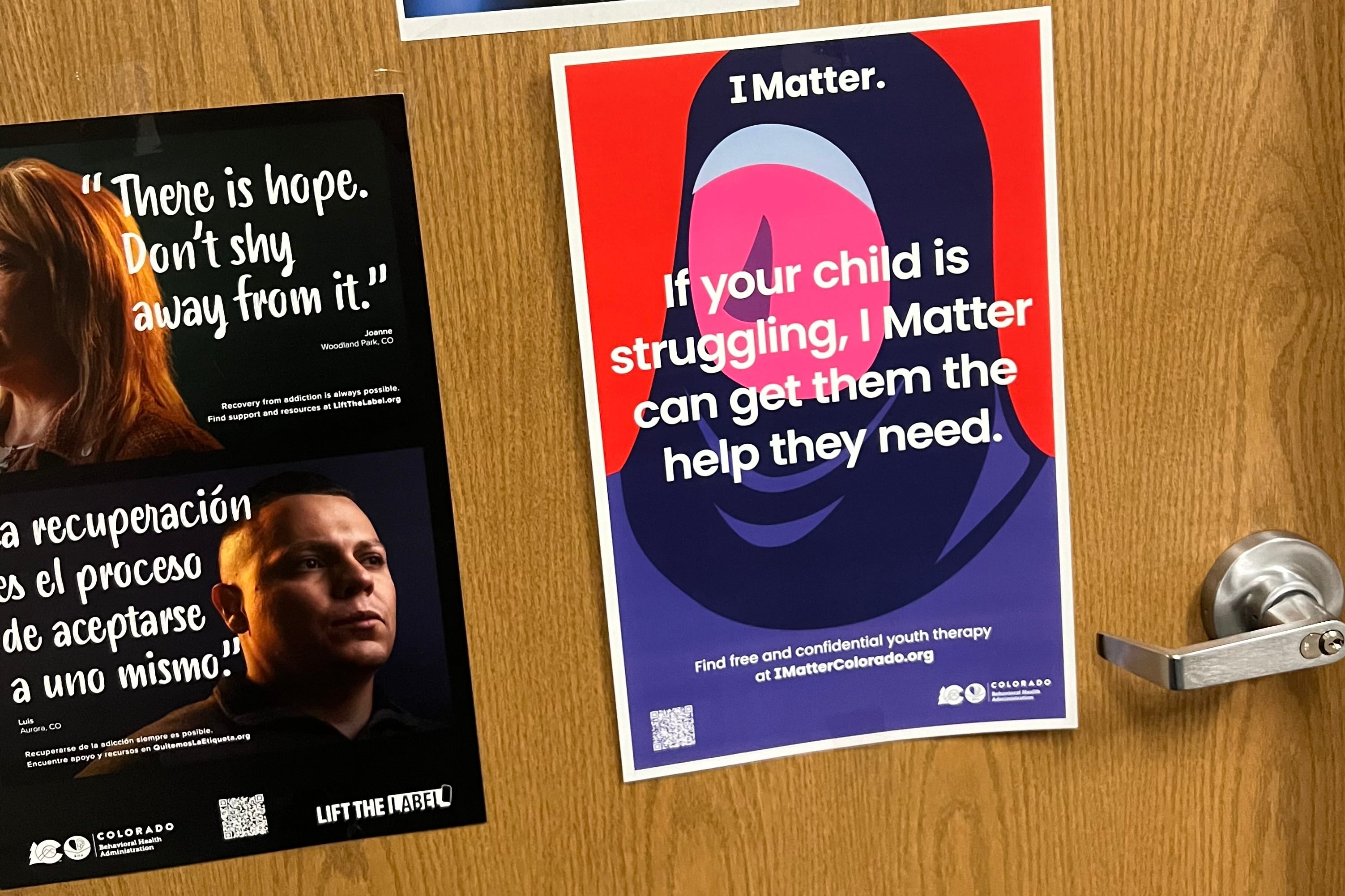 A red and purple poster on a wooden door advertises a free therapy program for students.