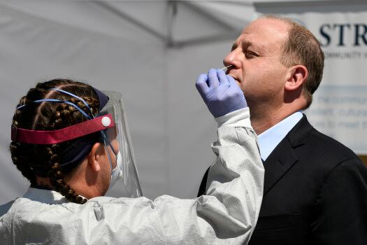 Colorado Gov. Jared Polis gets swabbed for a COVID test.