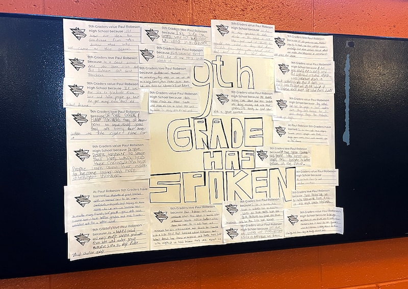 A sign hangs in a hallway.