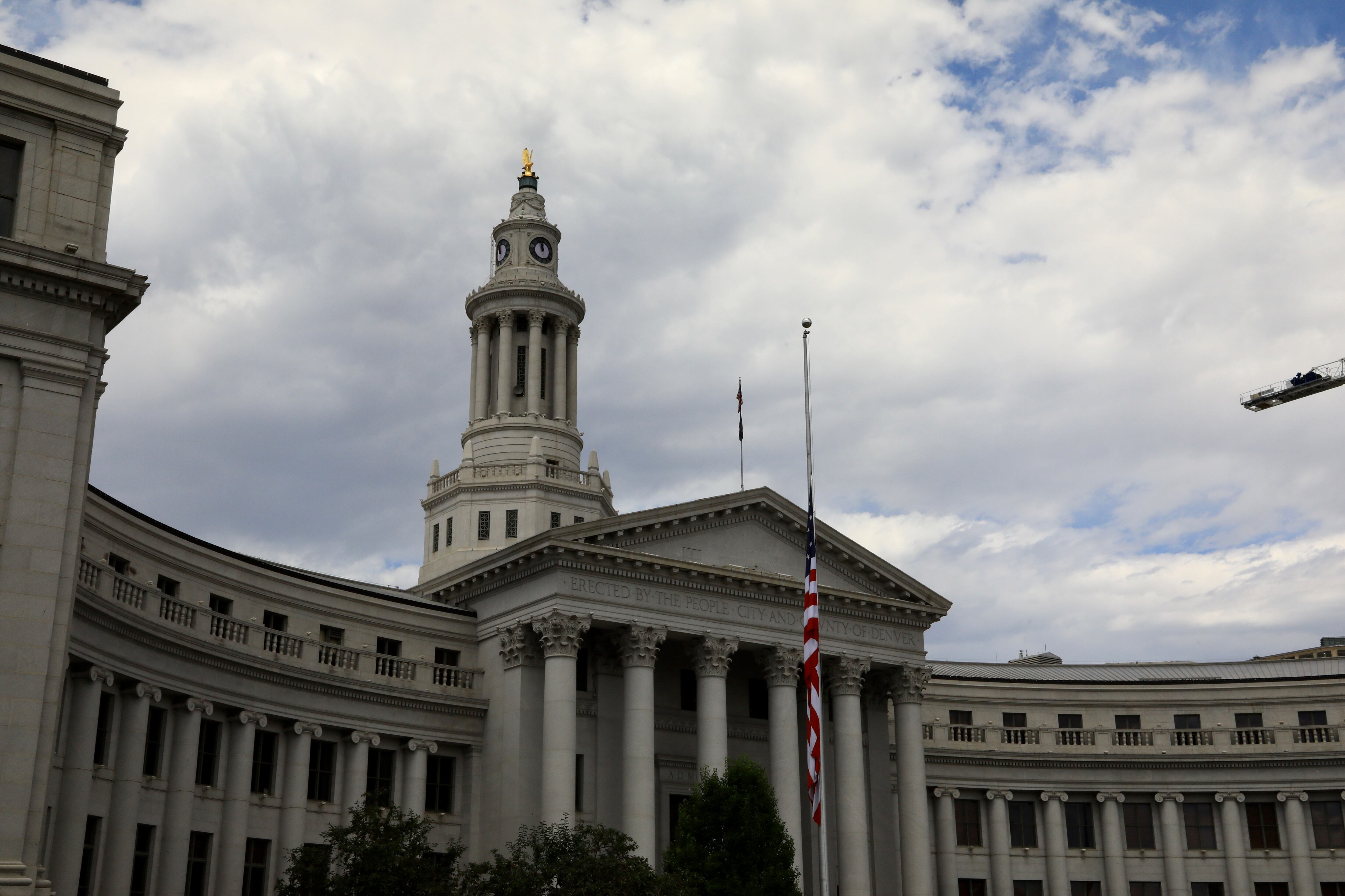 The front columns and tower of the Denver City and County building against a cloudy sky.  