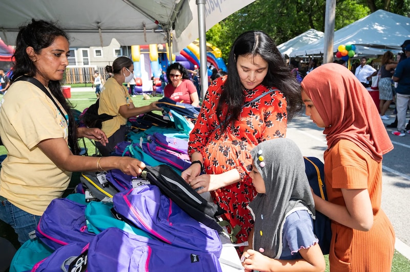 A family receives free purple backpacks at a back-to-school event in Chicago.