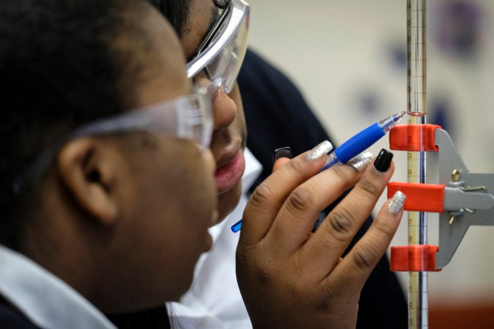 A close up view of two high school students working on a science assignment.
