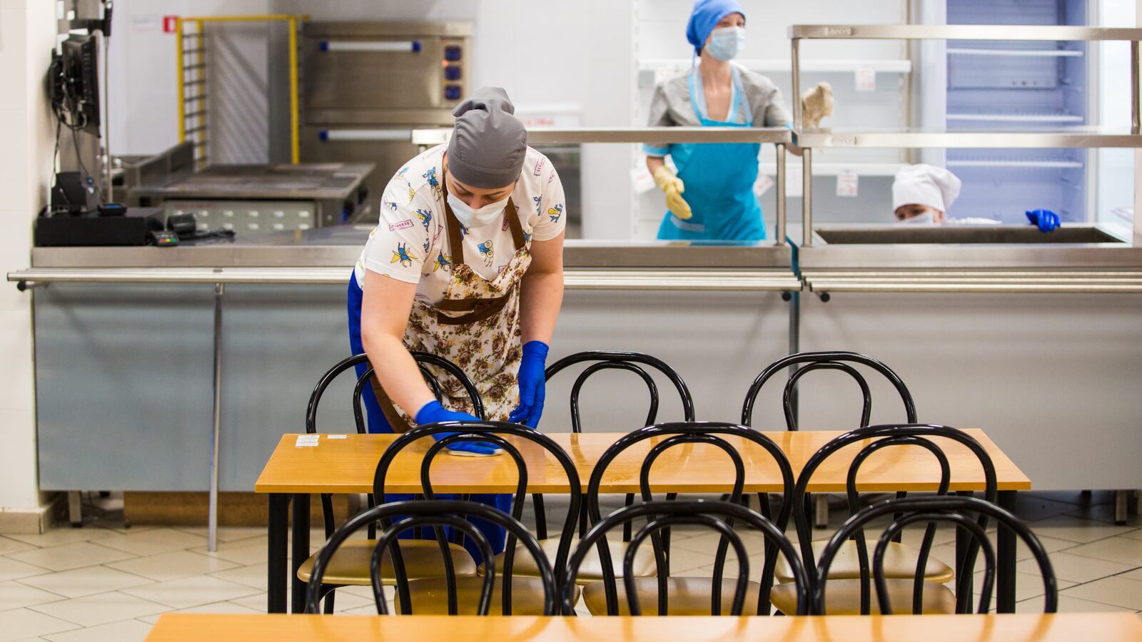 A woman sanitizes tables in a school dining hall in a school in Russia. All schools and preschools in Ulan-Ude are closed.