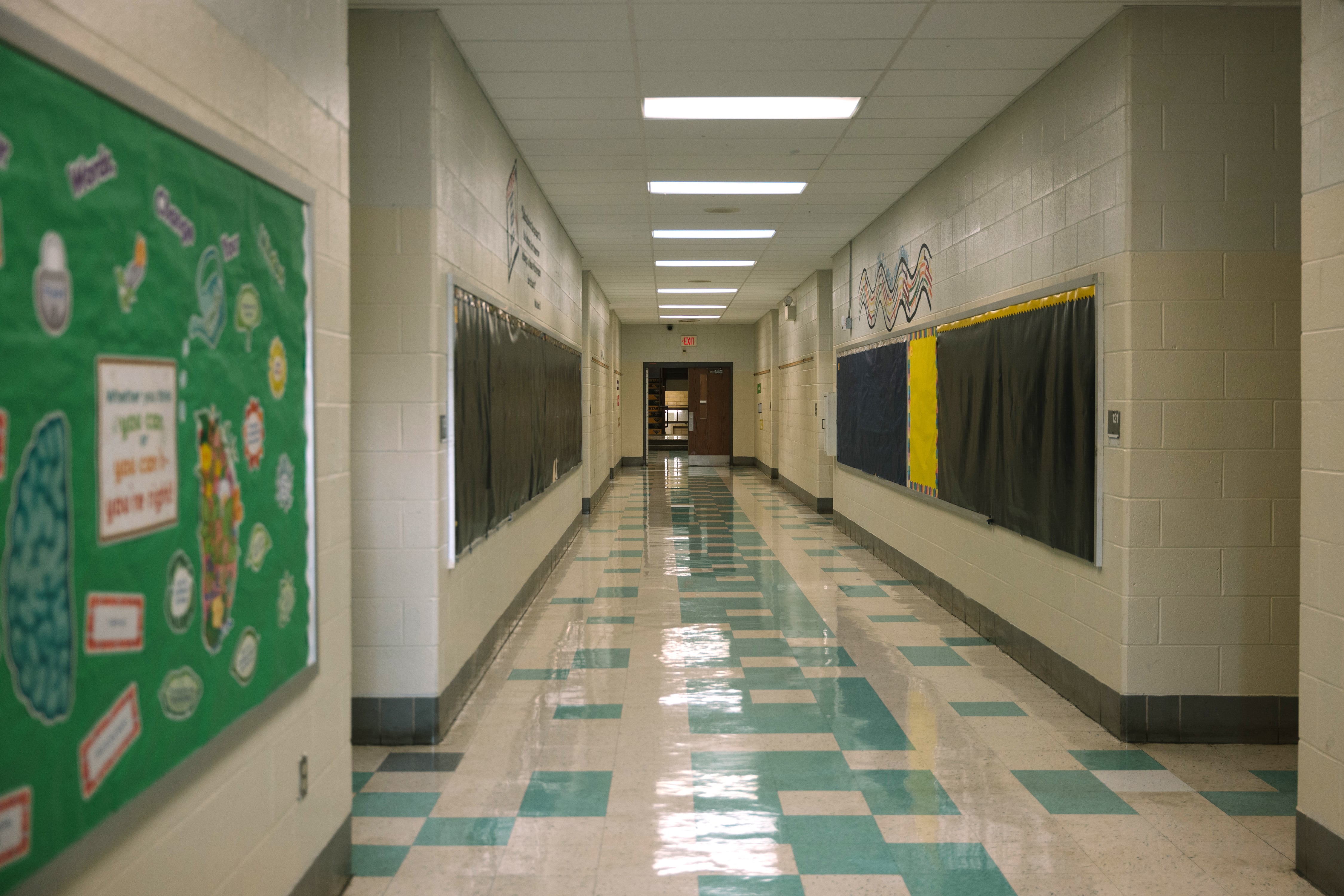 An empty school hallway with lockers on the sides.