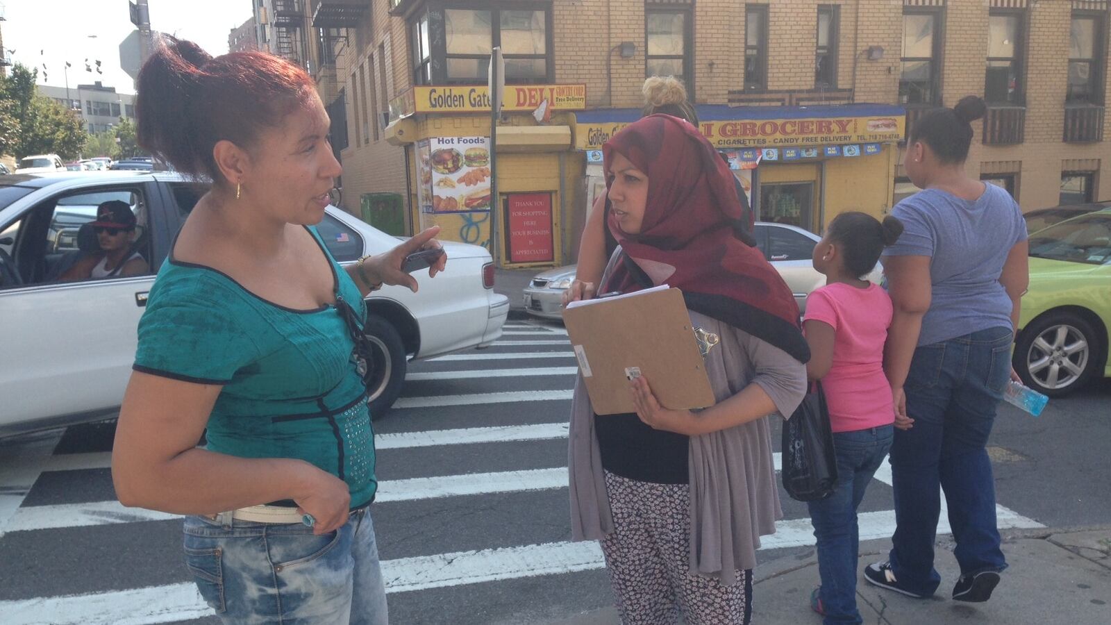 Parent Action Committee organizer Dinu Ahmed speaking with a parent outside I.S. 117 in the Bronx on Thursday.
