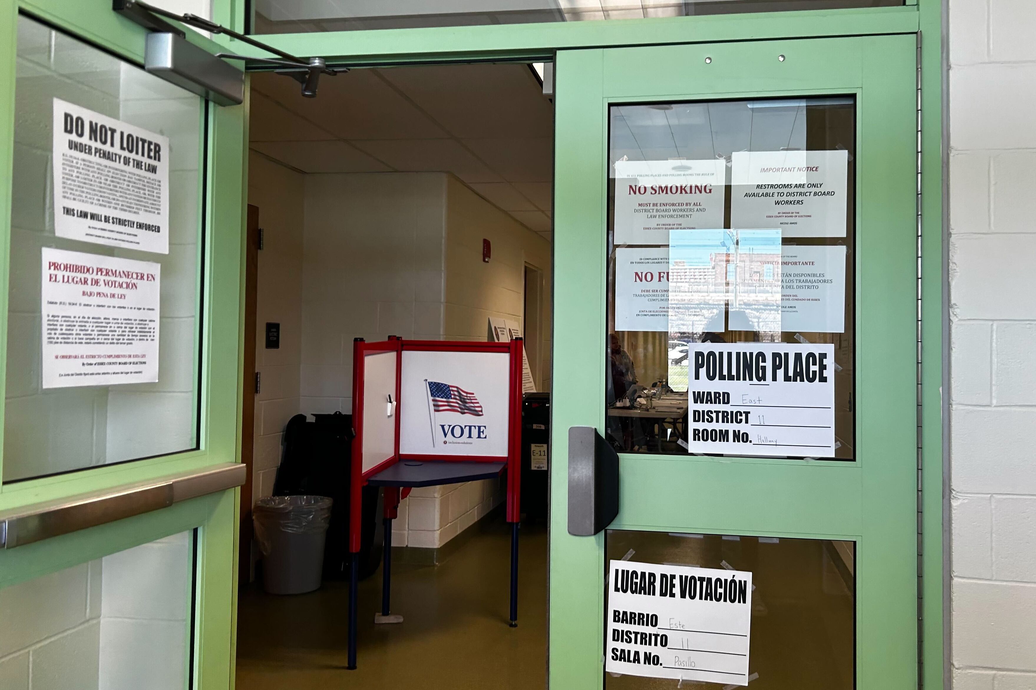 An open green door with voting information taped on.