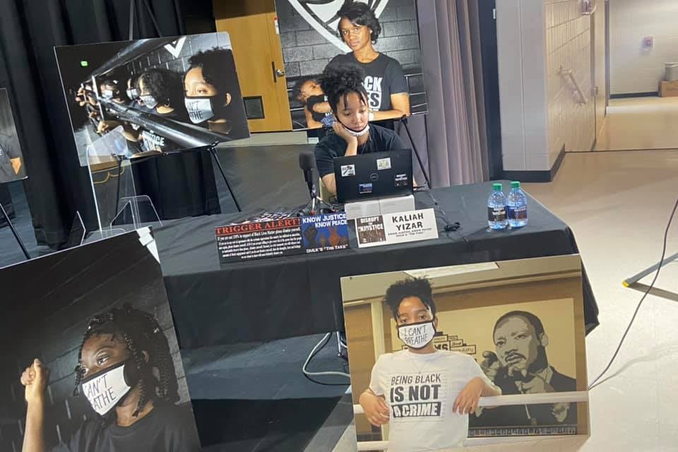 A female student sits behind a desk with recording equipment.