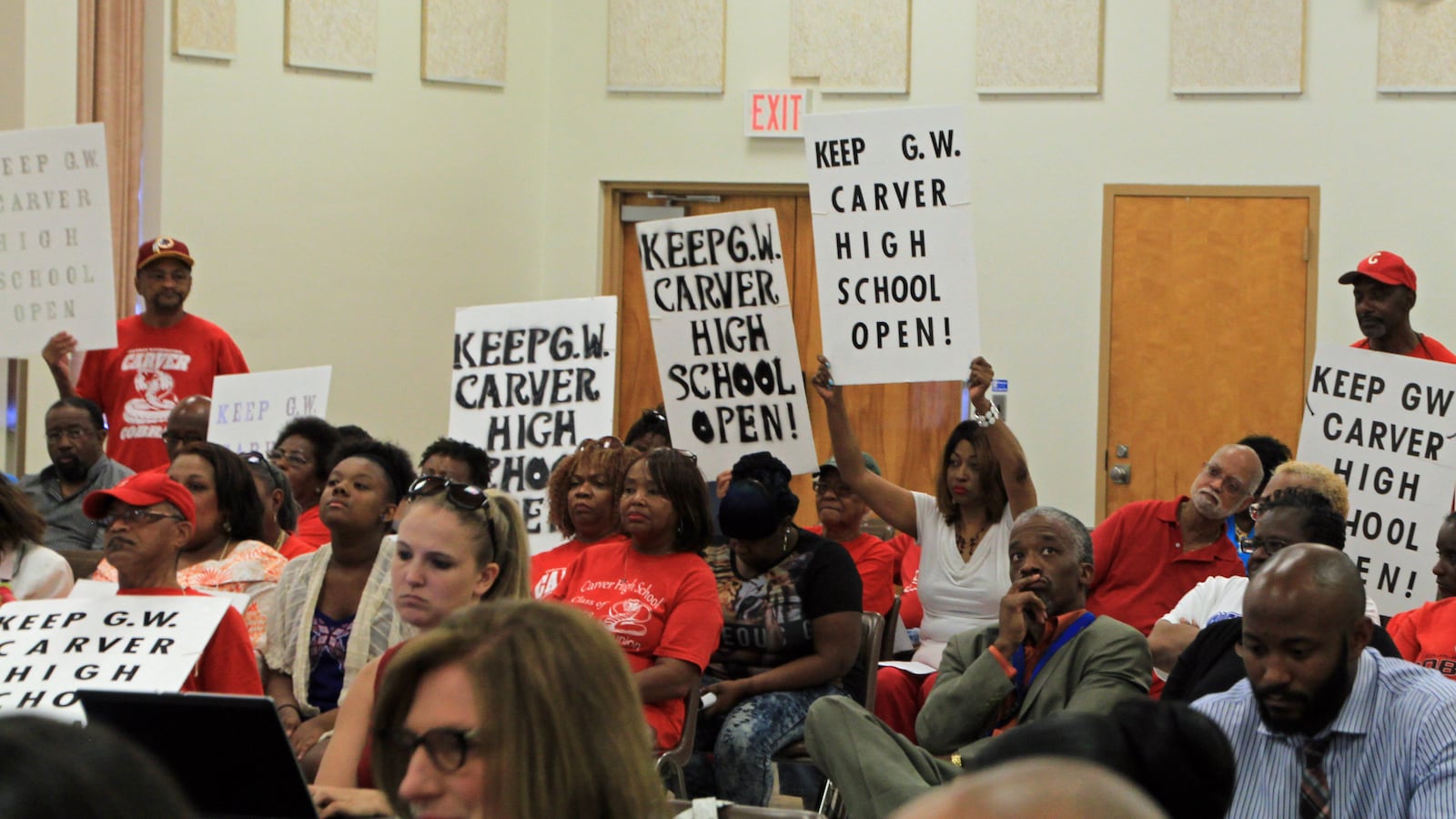 Proponents of keeping Carver High School open show their support during a school board meeting last spring. The school was closed a few months later.