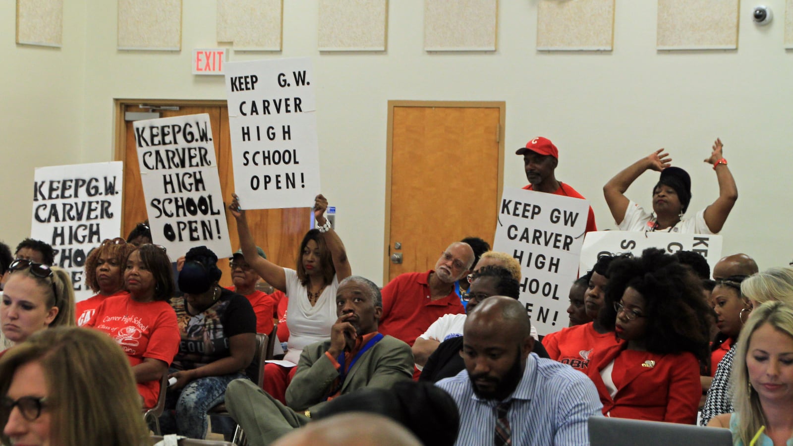Proponents of keeping Carver High School open show their support during a school board meeting last spring. The school was closed a few months later.