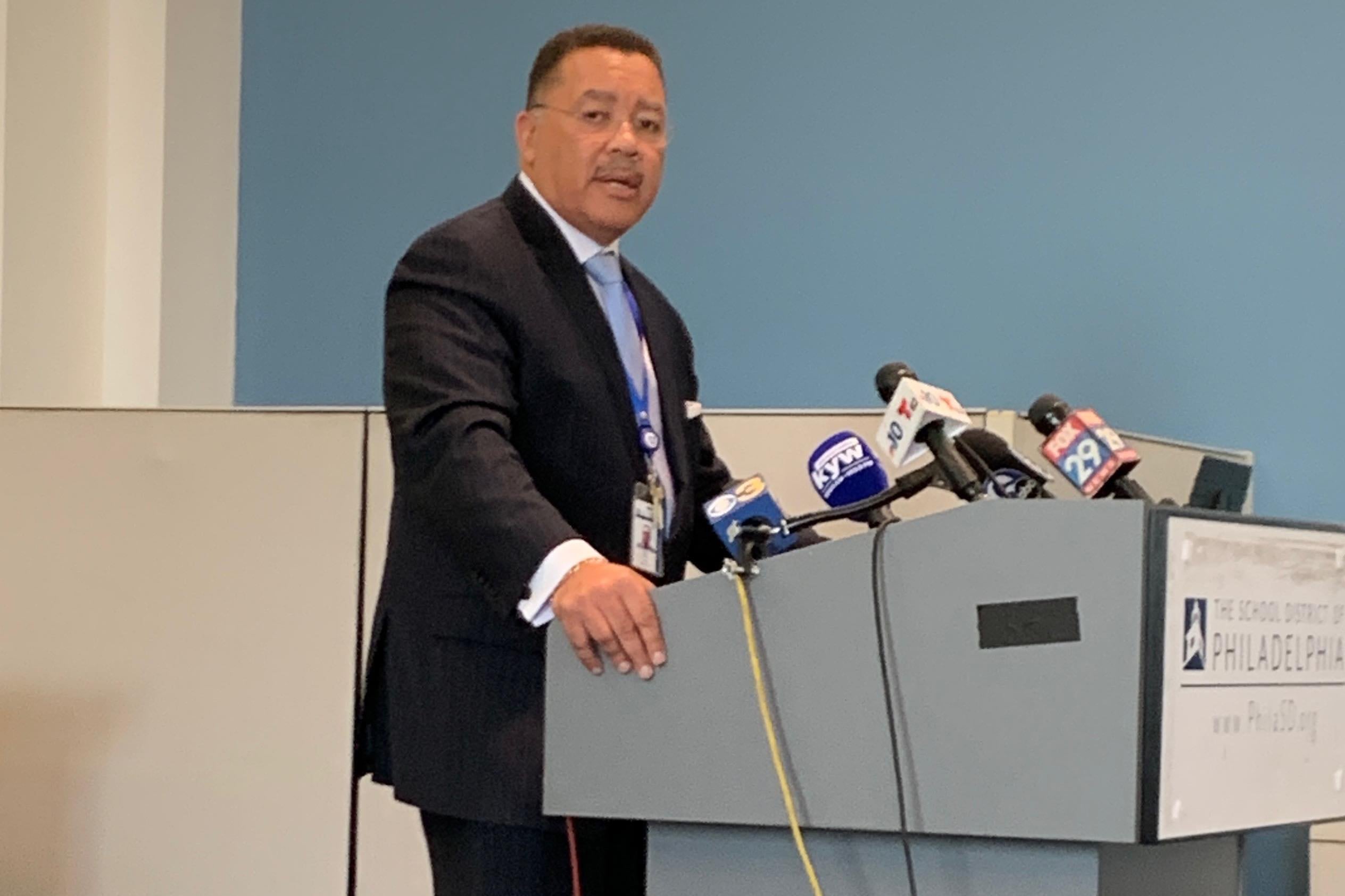 Kevin Bethel stands at a podium with microphones attached.