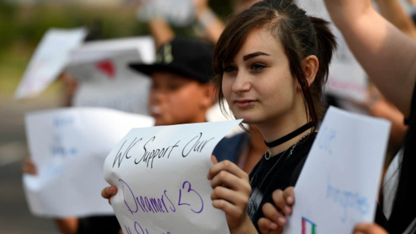 Arieona Duvall-Valverde, a ninth grader at Denver's North High, holds a sign in support of the Deferred Action for Childhood Arrivals program in September 2017.