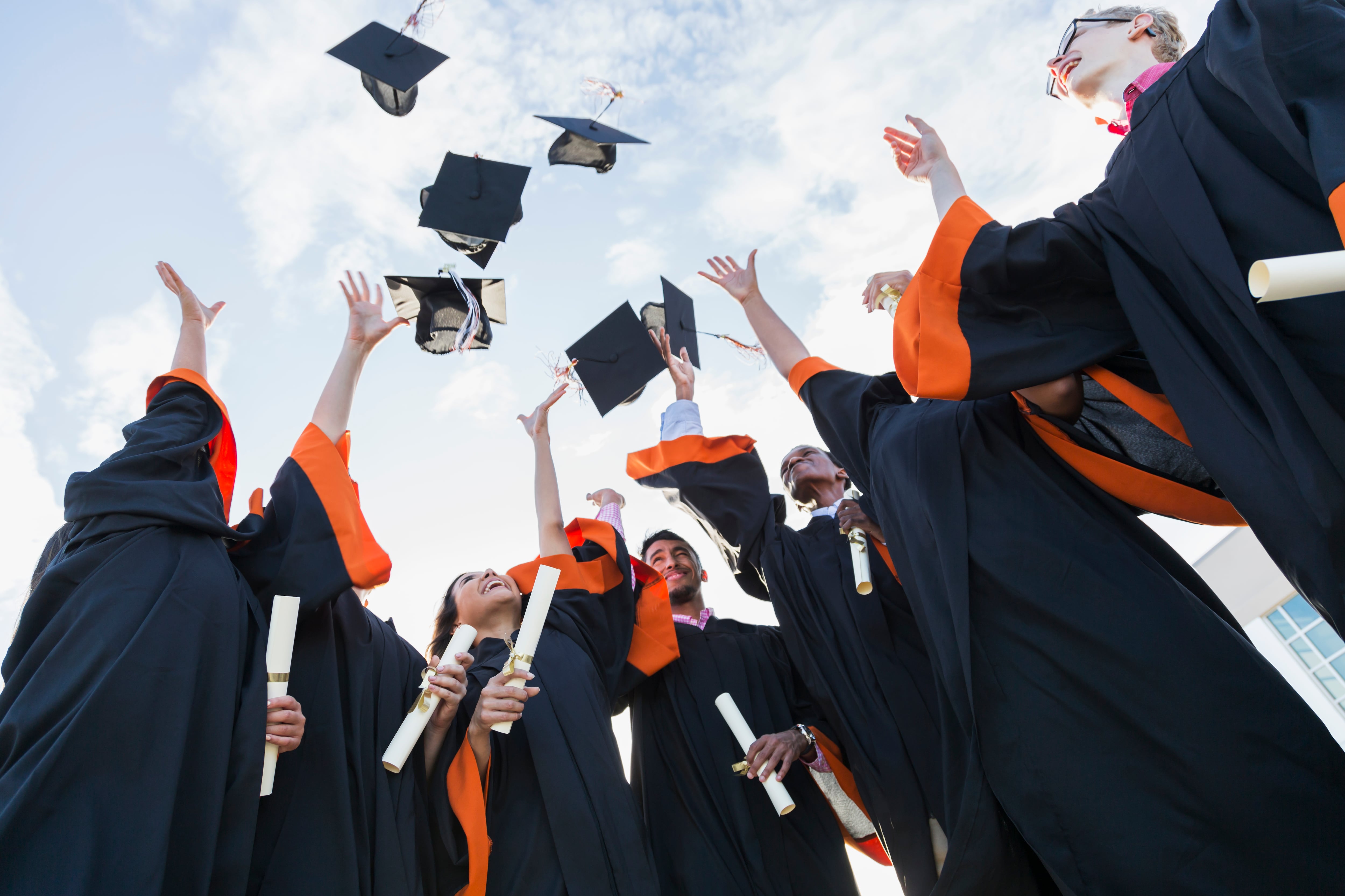 students throw graduation caps