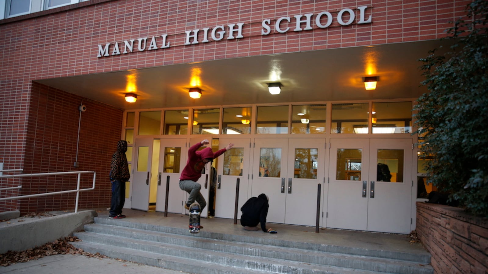 A student skateboards across an entrance at Manual High School. Throughout the much success has been promised the school in northeast Denver with little to show for it.