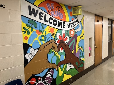 A colorful mural on a wall inside of a school.