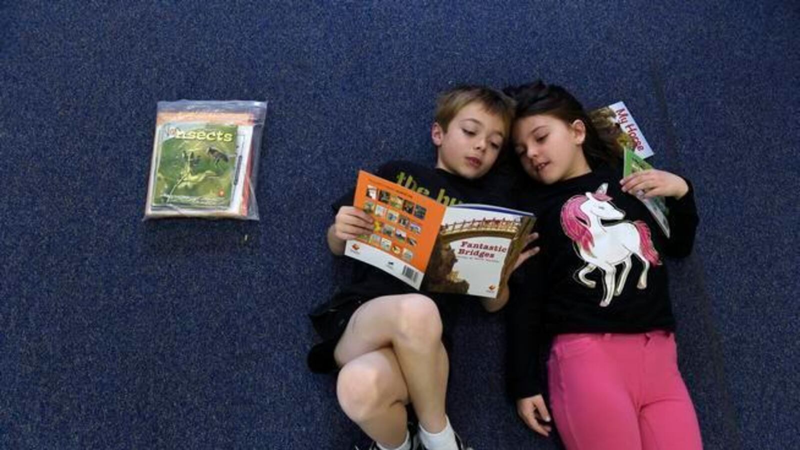 Van Current, 6, left, and Natasha Williams, 7, read quietly together at Denver Green School.
