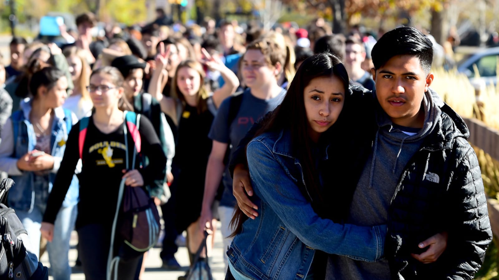 Rayne Macias, of Fairview High, and Jason Segovia, hug as they walk down the street with protesting Boulder High students. (Cliff Grassmick, Boulder Daily Camera)