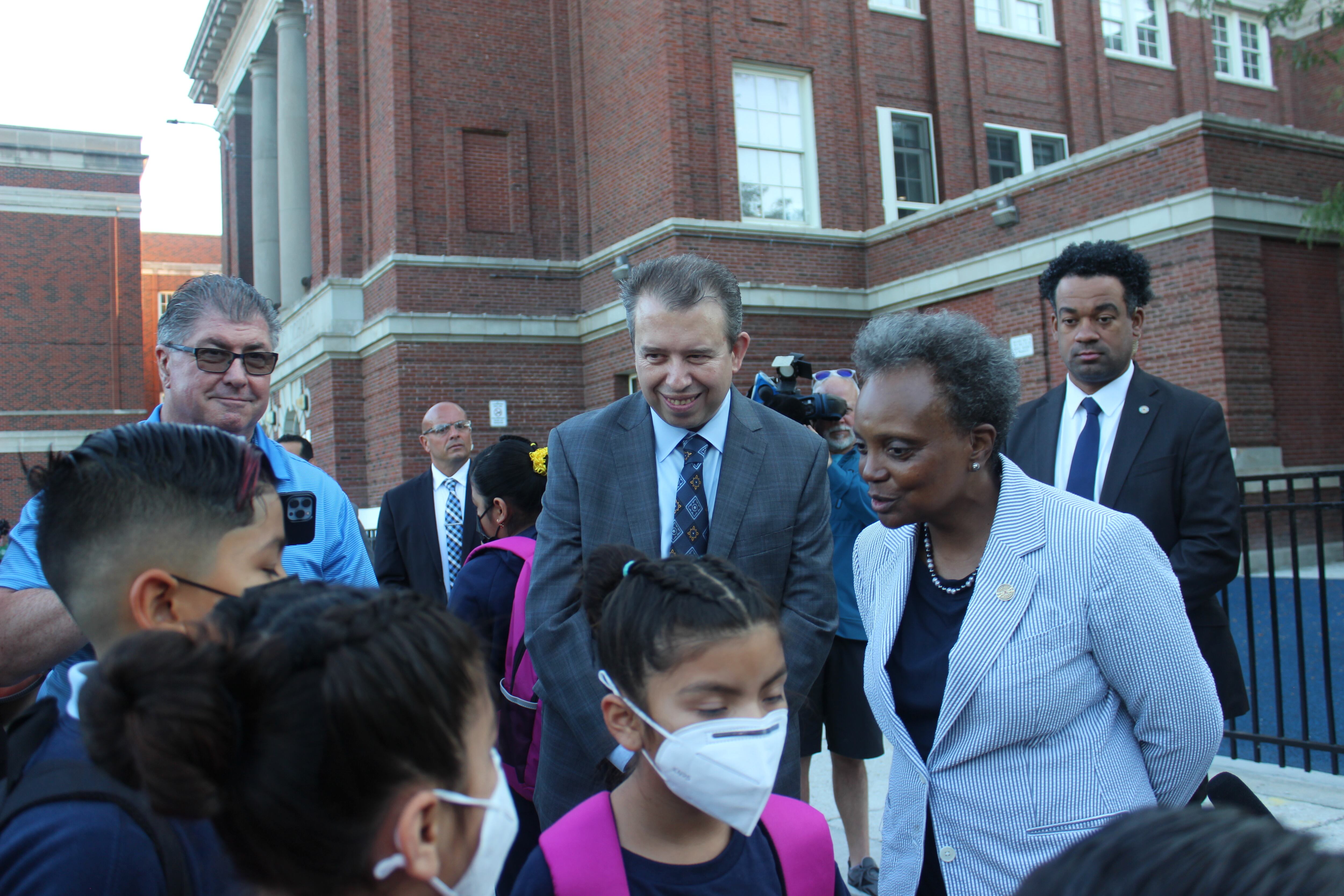A man and woman greet children on their first day back to school in Chicago.
