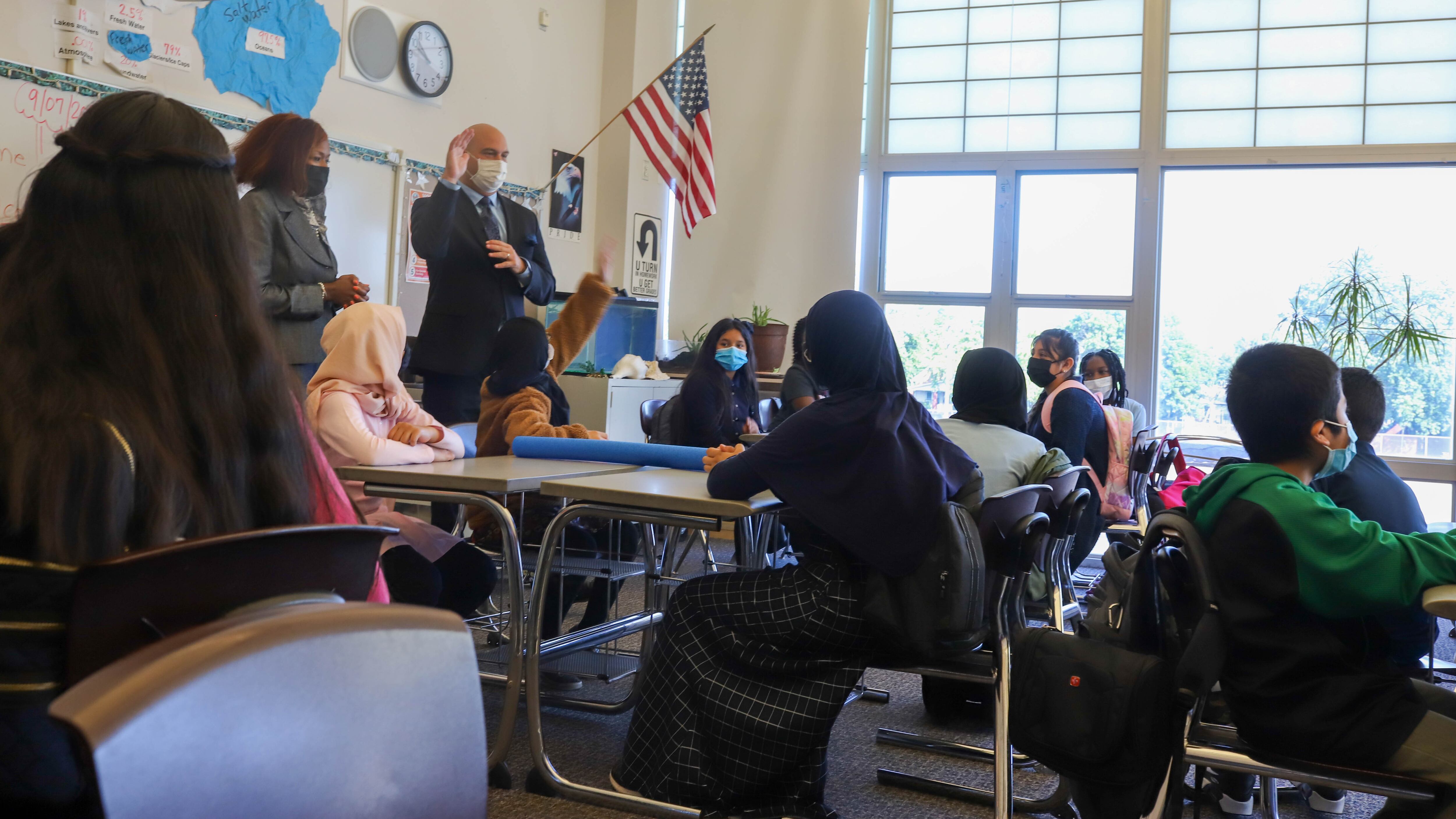 Superintendent Dr. Nikolai Vitti and Detroit Public Schools Board President Angelique Peterson-Mayberry speak with a classroom of full of students.