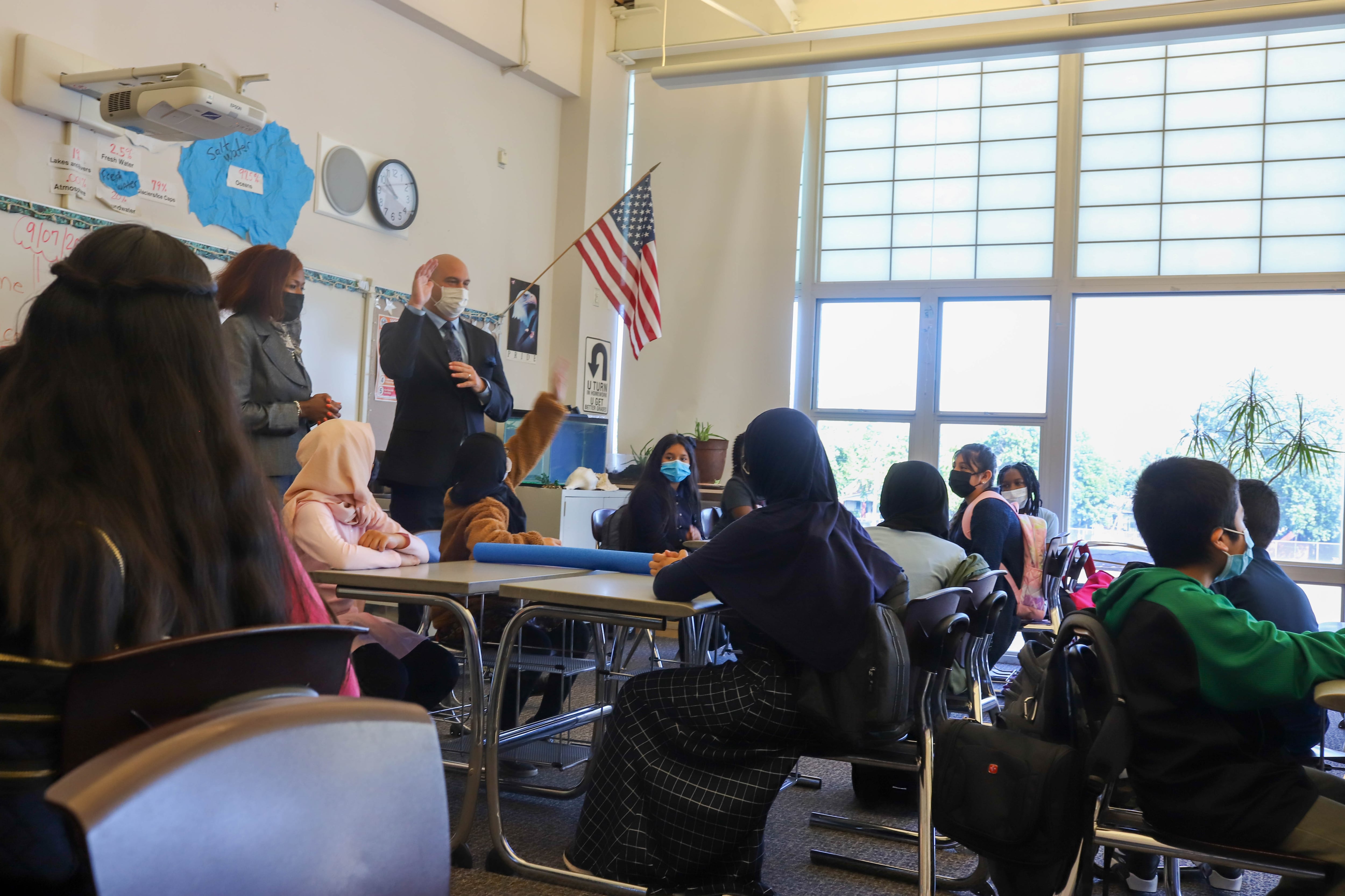 Superintendent Dr. Nikolai Vitti and Detroit Public Schools Board President Angelique Peterson-Mayberry speak with a classroom of full of students.