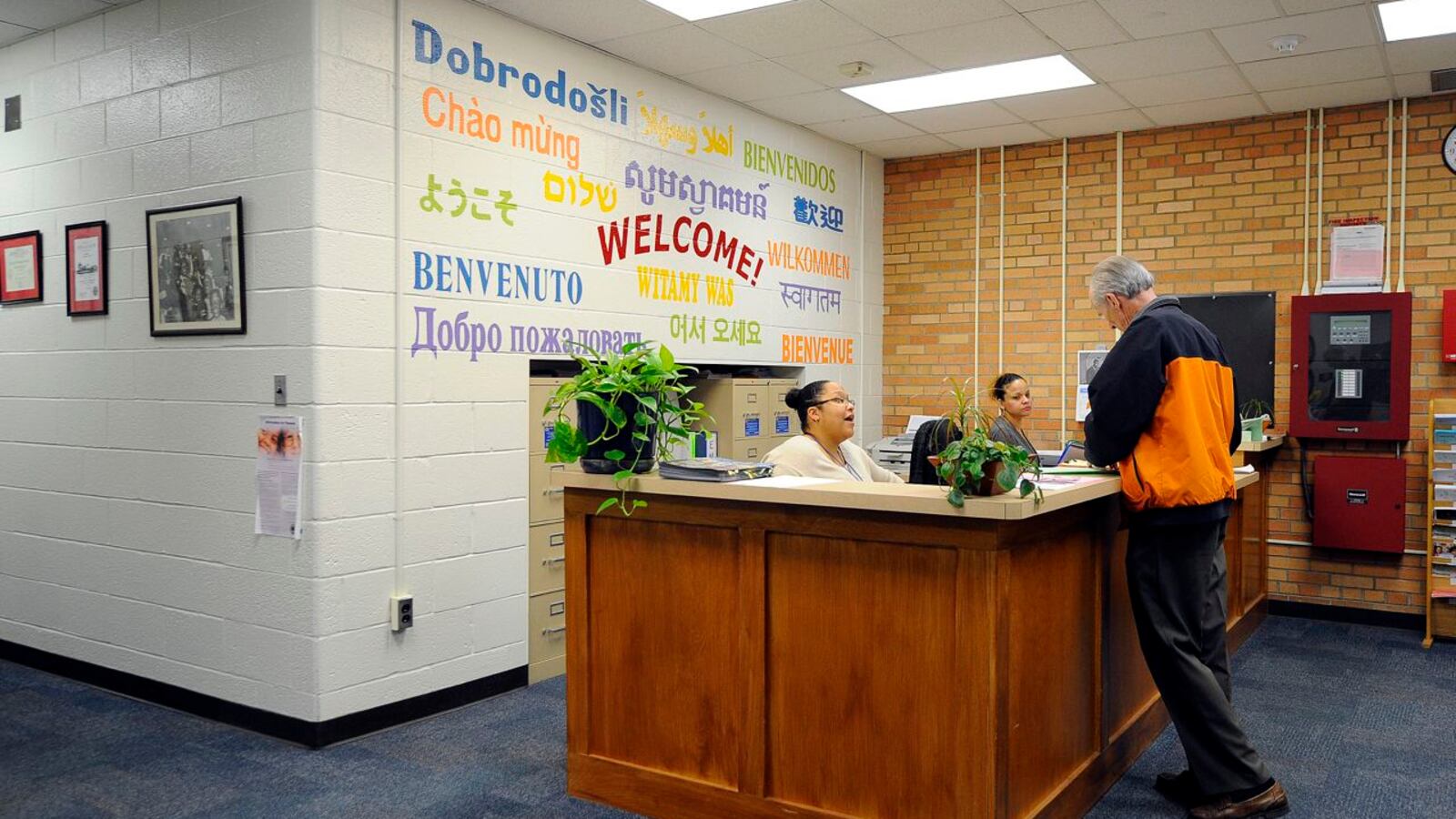 The front desk at School 27, a Center For Inquiry magnet school, welcomes students in several languages. CFI schools can cost more because they use specialized curriculum and teachers trained to use it.