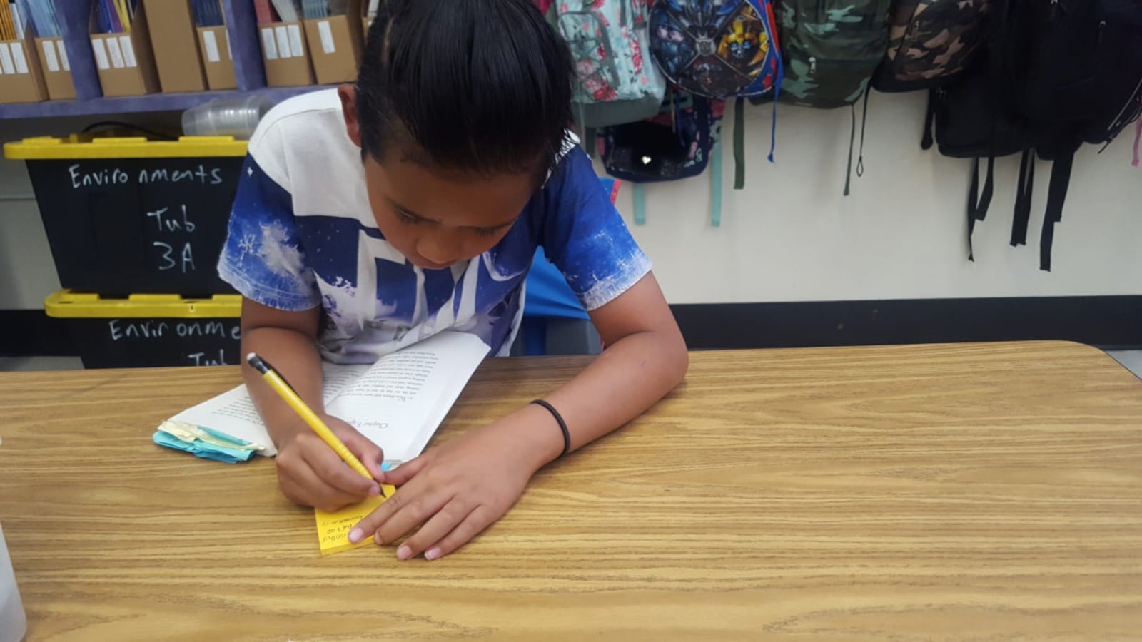 A fourth grader in Aurora's Peoria Elementary takes notes while reading.