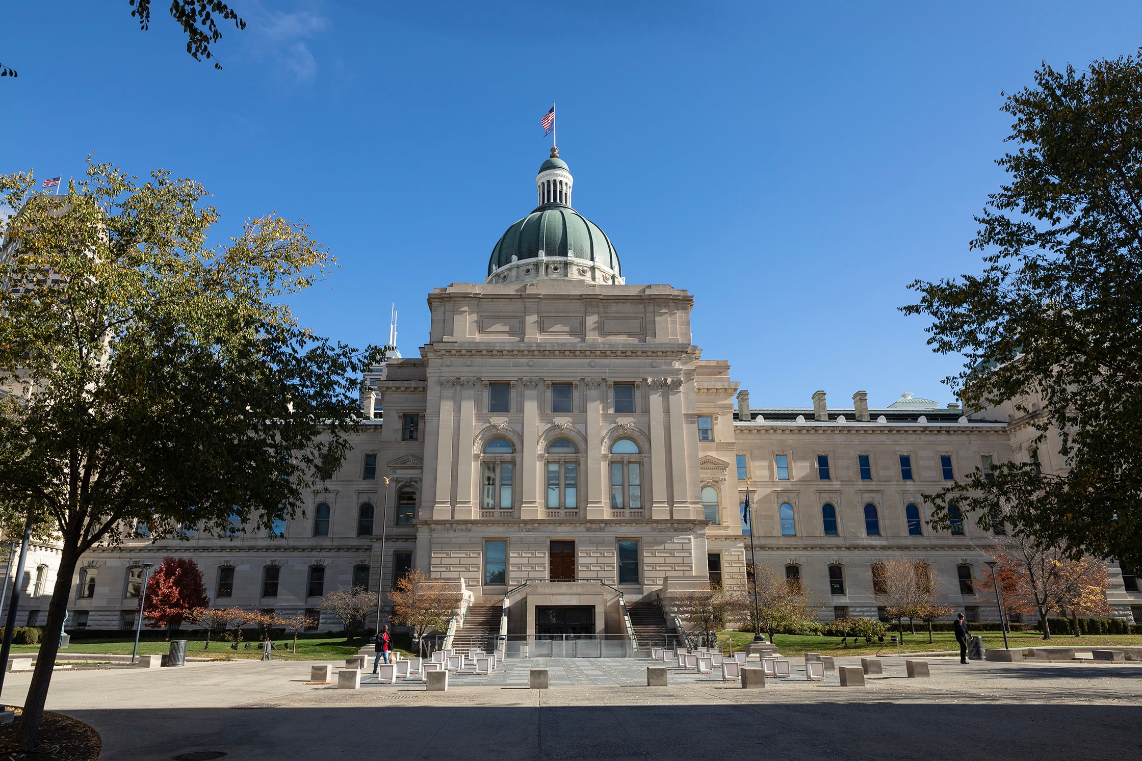 A large white stone building with a green dome and an American flag on the top.