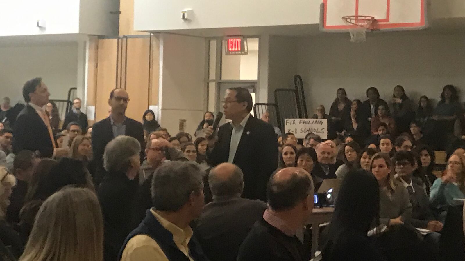 Attendees of a District 2 Community Education Council meeting listen as people speak out against a city plan to scrap the admissions test for specialized high schools.