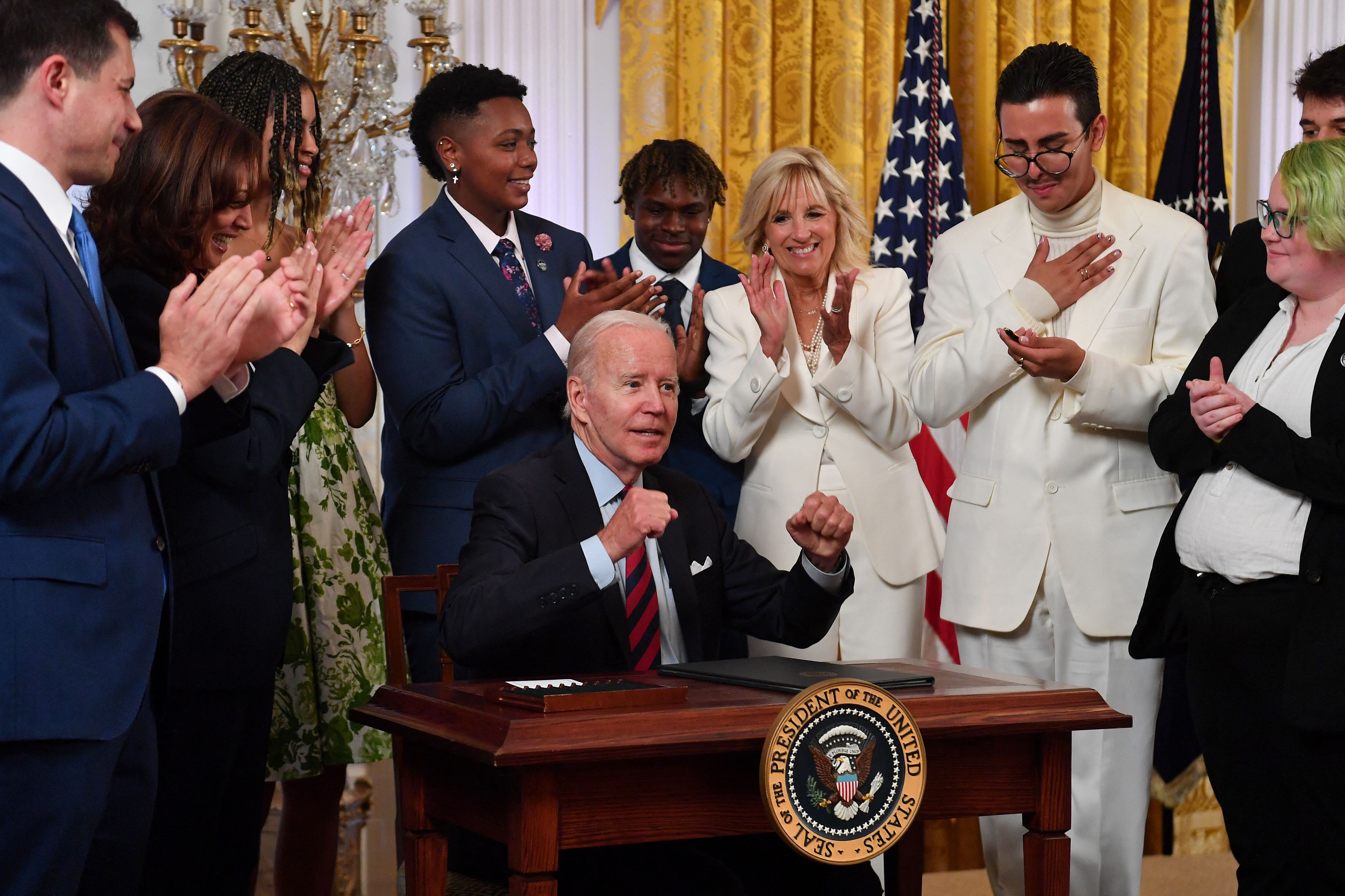 Supporters applaud during a White House ceremony this June after President Biden signs an executive order promoting LGBTQ rights.