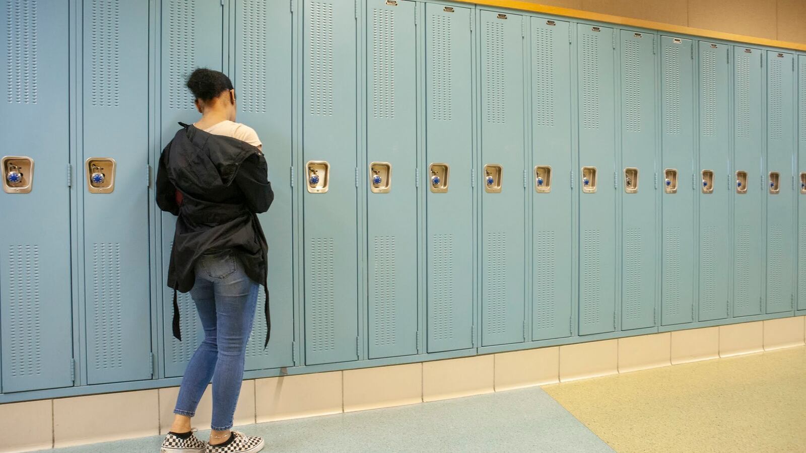 A student at her locker in a hallway at North-Grand High School in Chicago. Photo by Stacey Rupolo / Chalkbeat —May, 2019 photo—