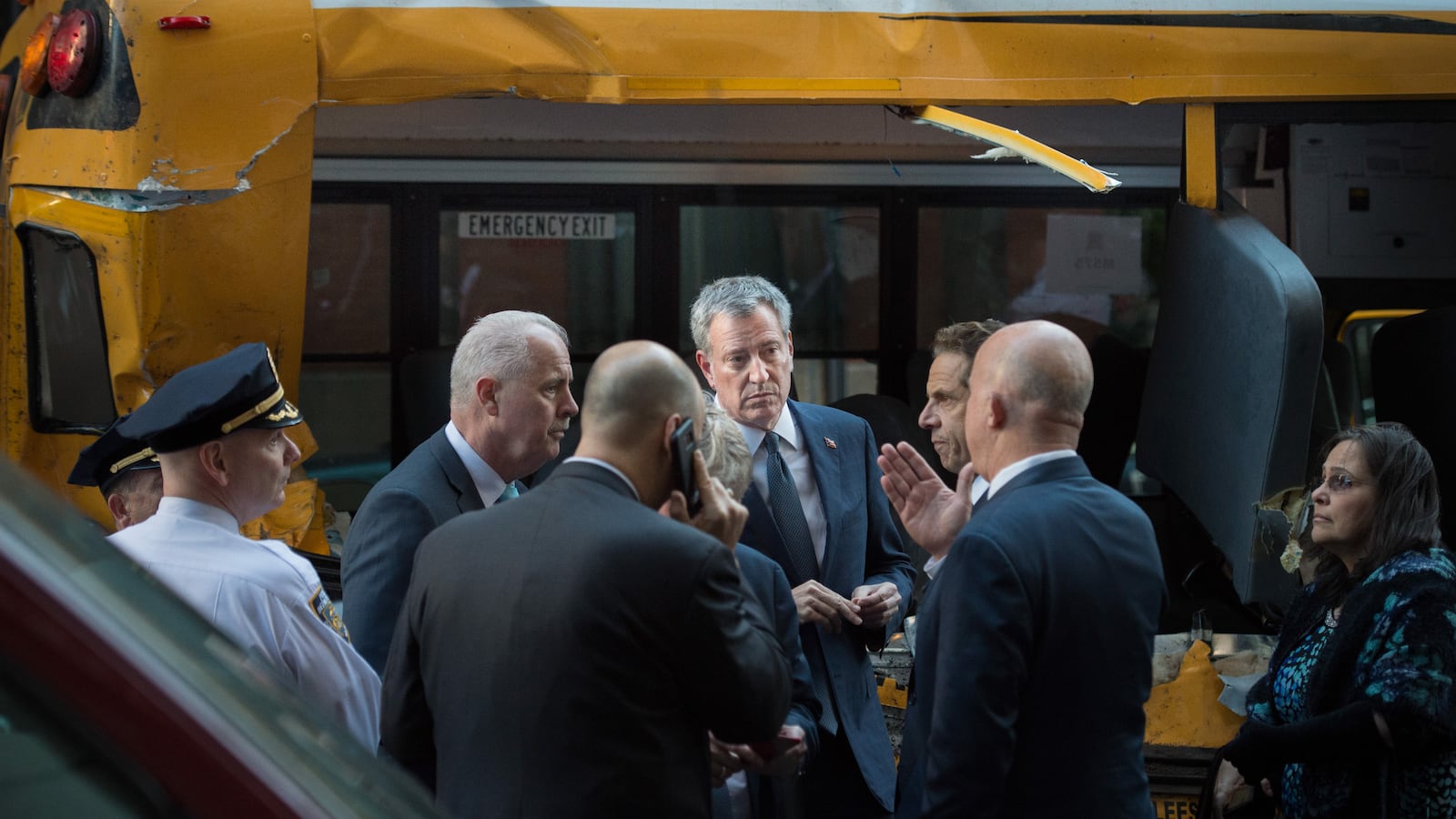 Mayor Bill de Blasio and Governor Andrew Cuomo stand in front of the school bus mangled in Tuesday's attack.