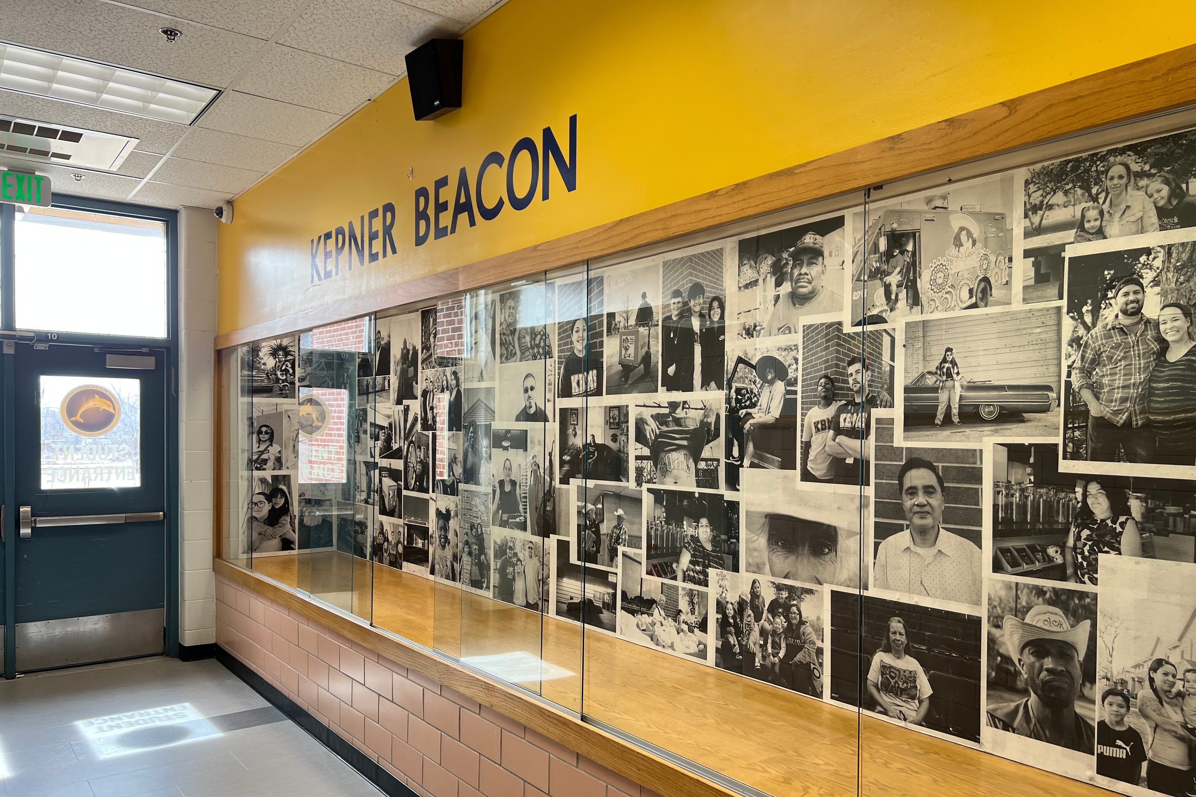 Image shows a display case full of black-and-white photos in the entry way of Kepner Beacon Middle School. The words Kepner Beacon appear above in a yellow field.