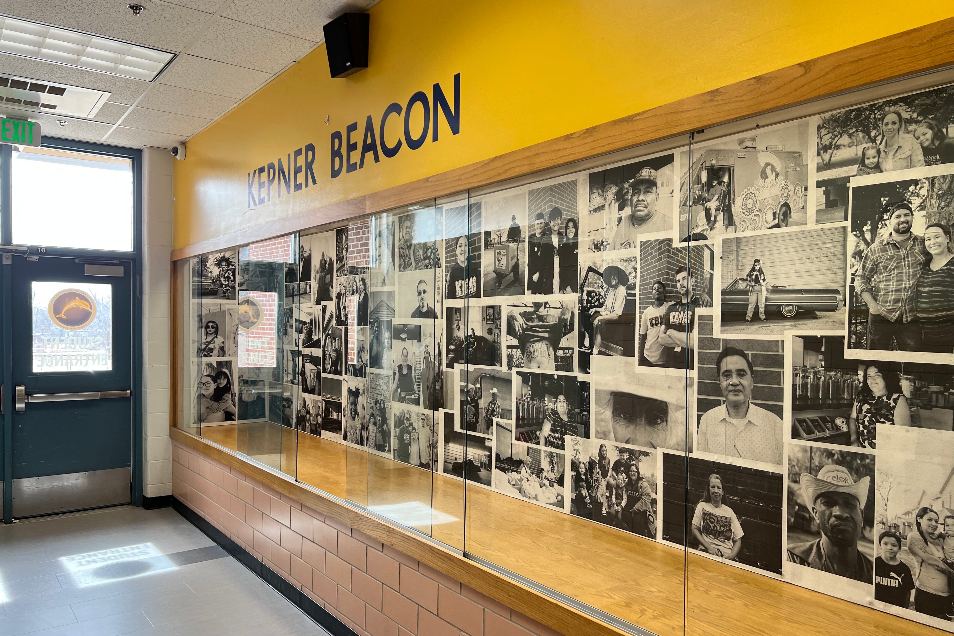 Image shows a display case full of black-and-white photos in the entry way of Kepner Beacon Middle School. The words Kepner Beacon appear above in a yellow field.