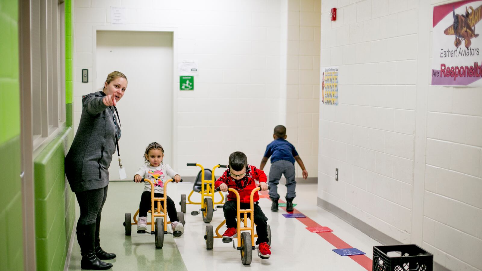 Pre-K students ride tricycles in the halls at Earhart Elementary-Middle school in southwest Detroit.