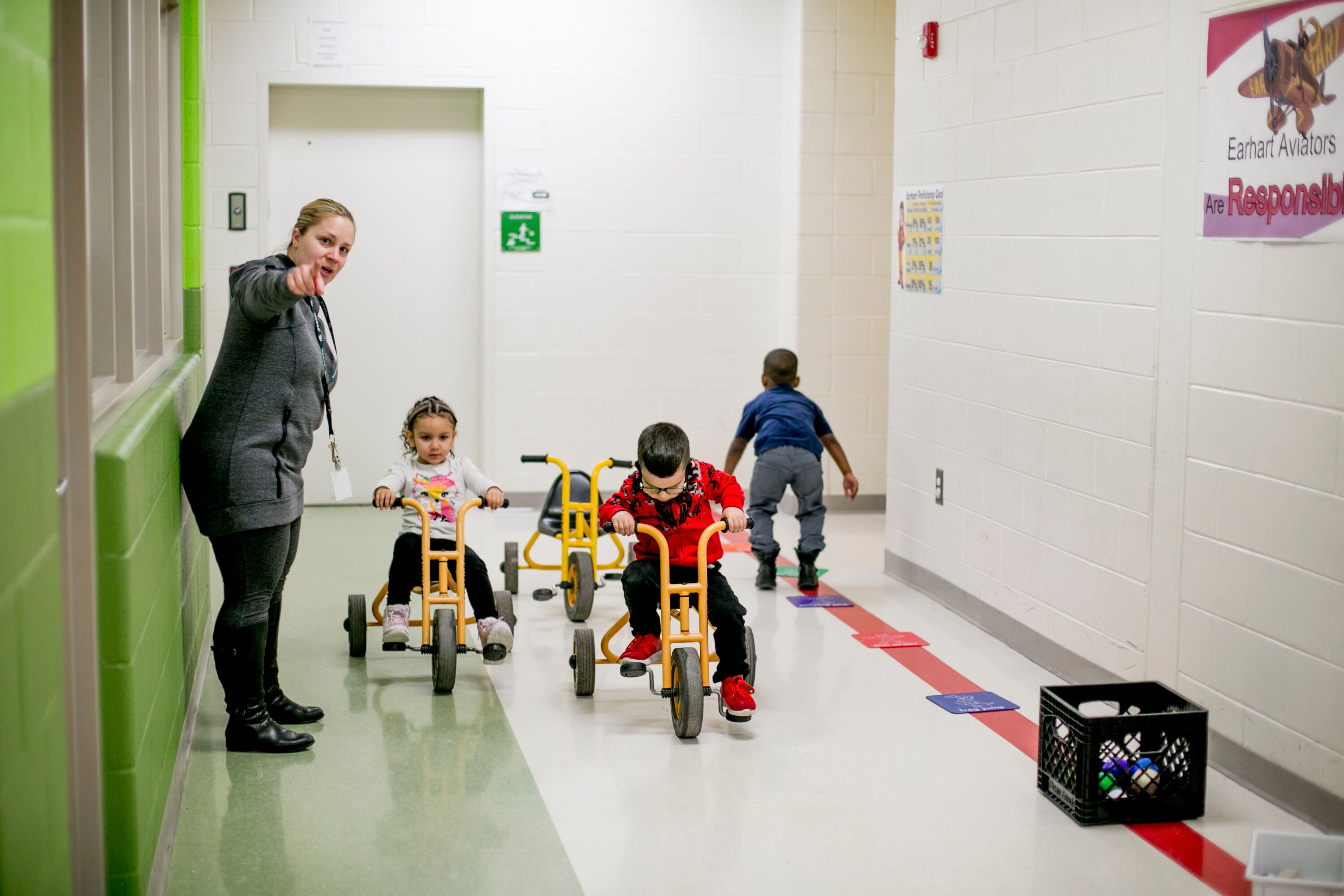 Pre-K students ride tricycles in the halls at Earhart Elementary-Middle school in southwest Detroit.