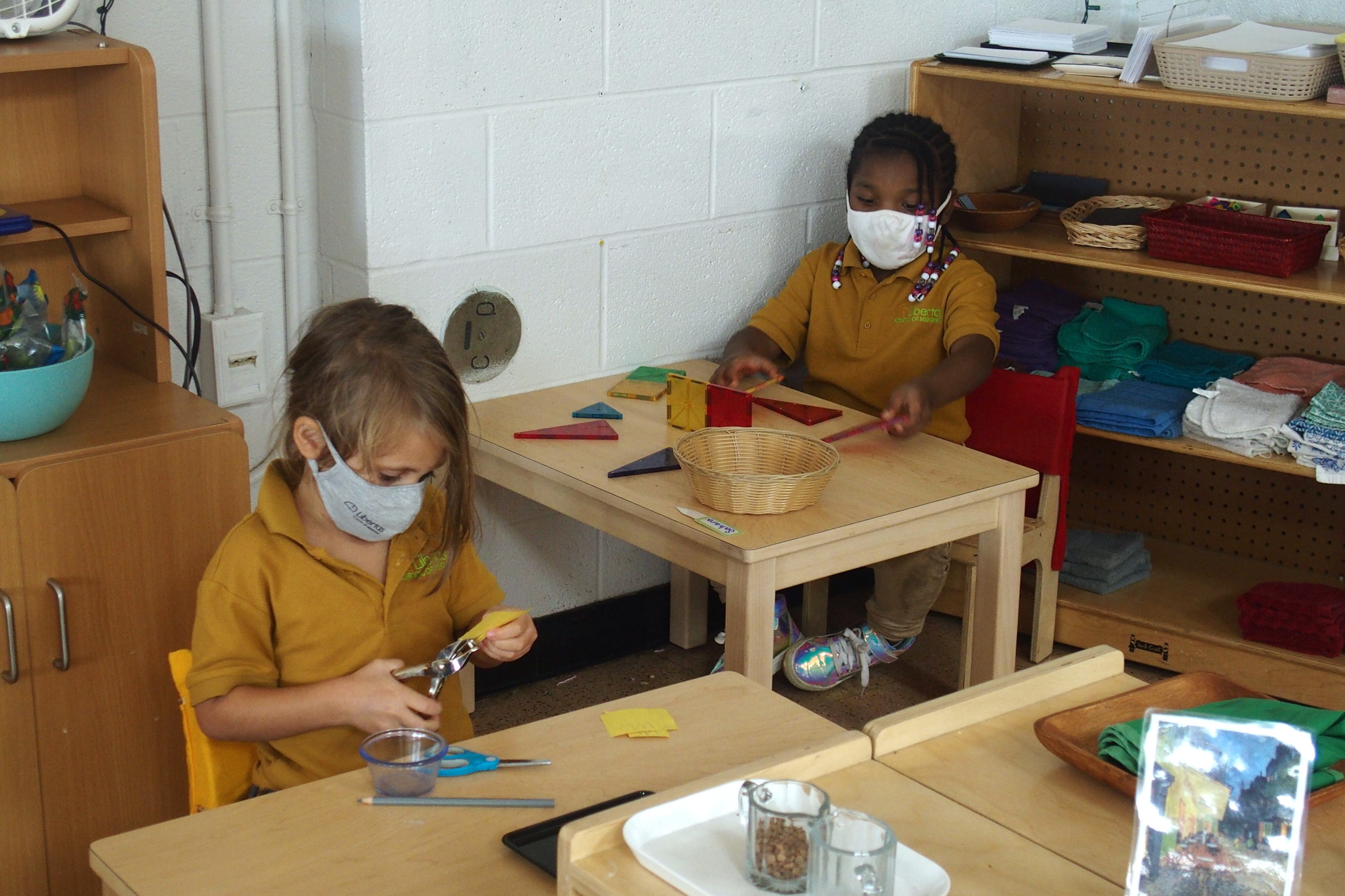 Elementary school students work at their desks with masks on