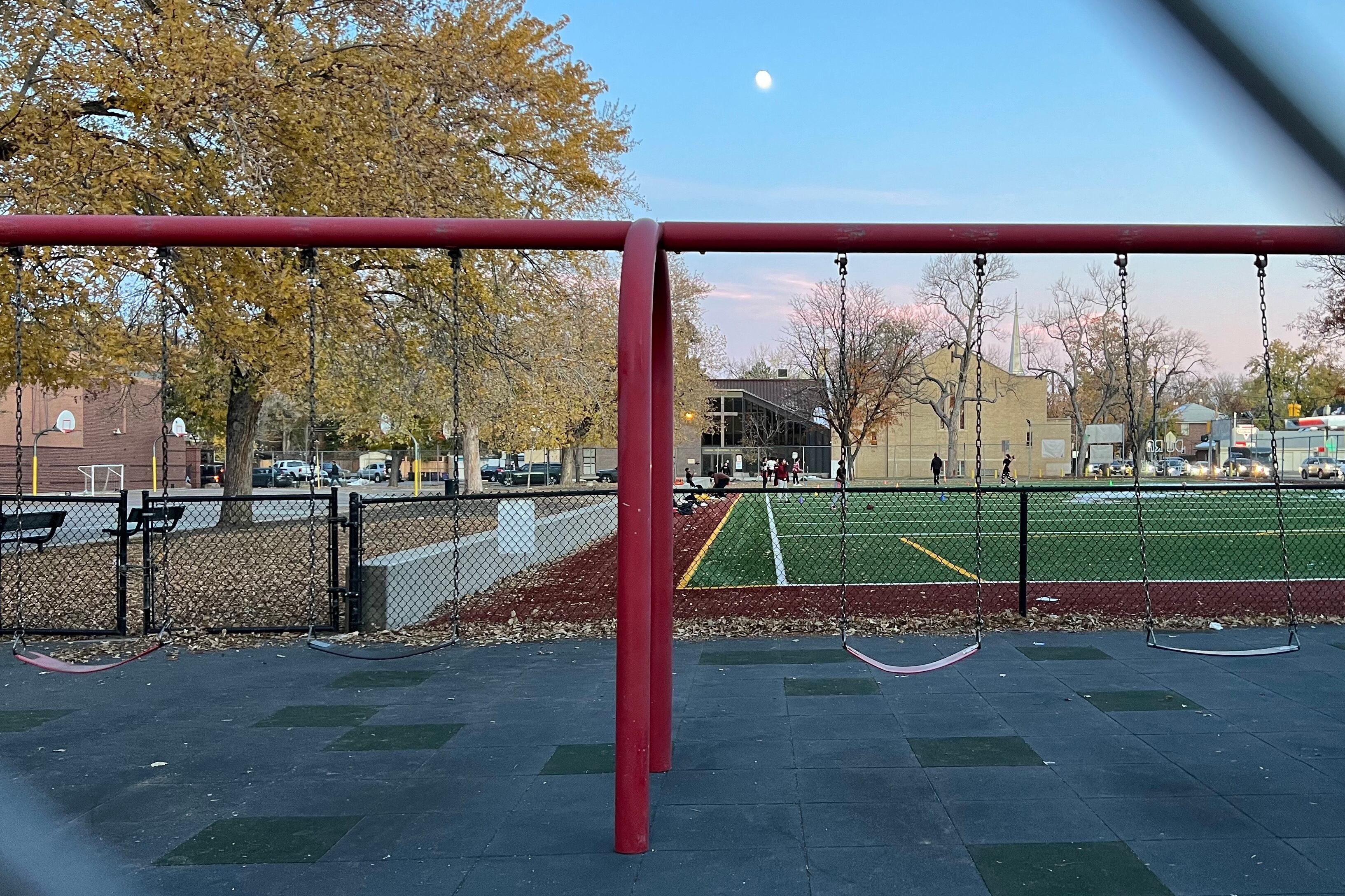 A school playground with a sports field in the background.