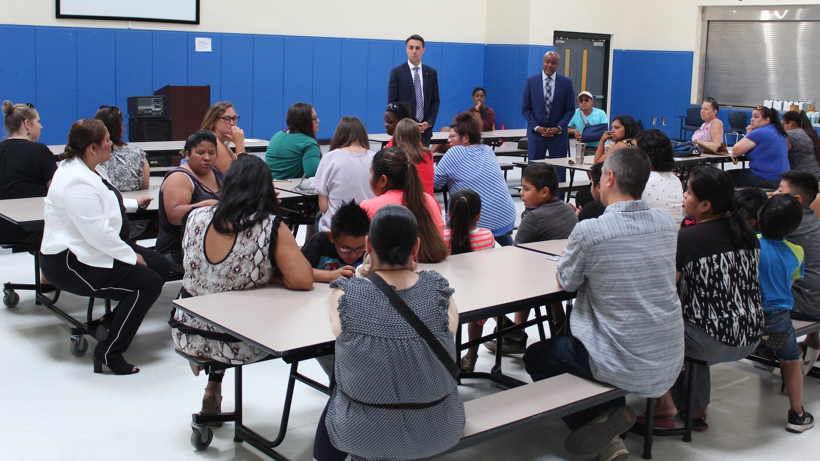 Rob Kimball, of Grand Valley State University (back left), and Ralph Bland, of New Paradigm for Education (back right), told parents that they hoped to be ready to start a new school by August 1.