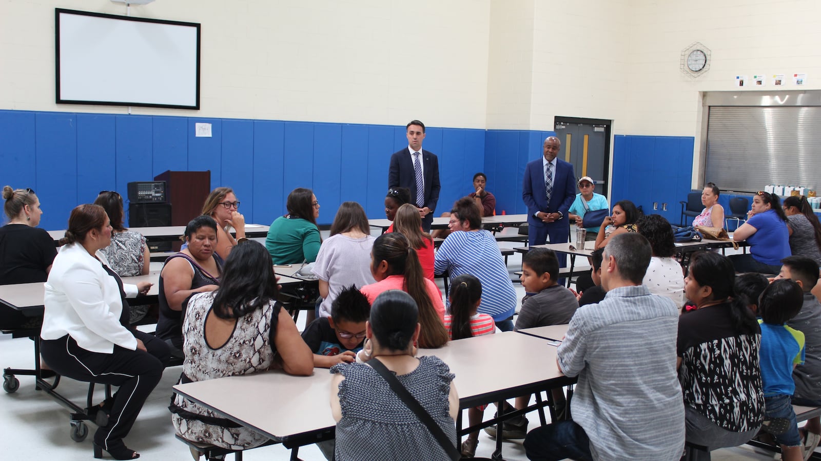 Rob Kimball, of Grand Valley State University (back left), and Ralph Bland, of New Paradigm for Education (back right), told parents that they hoped to be ready to start a new school by August 1.