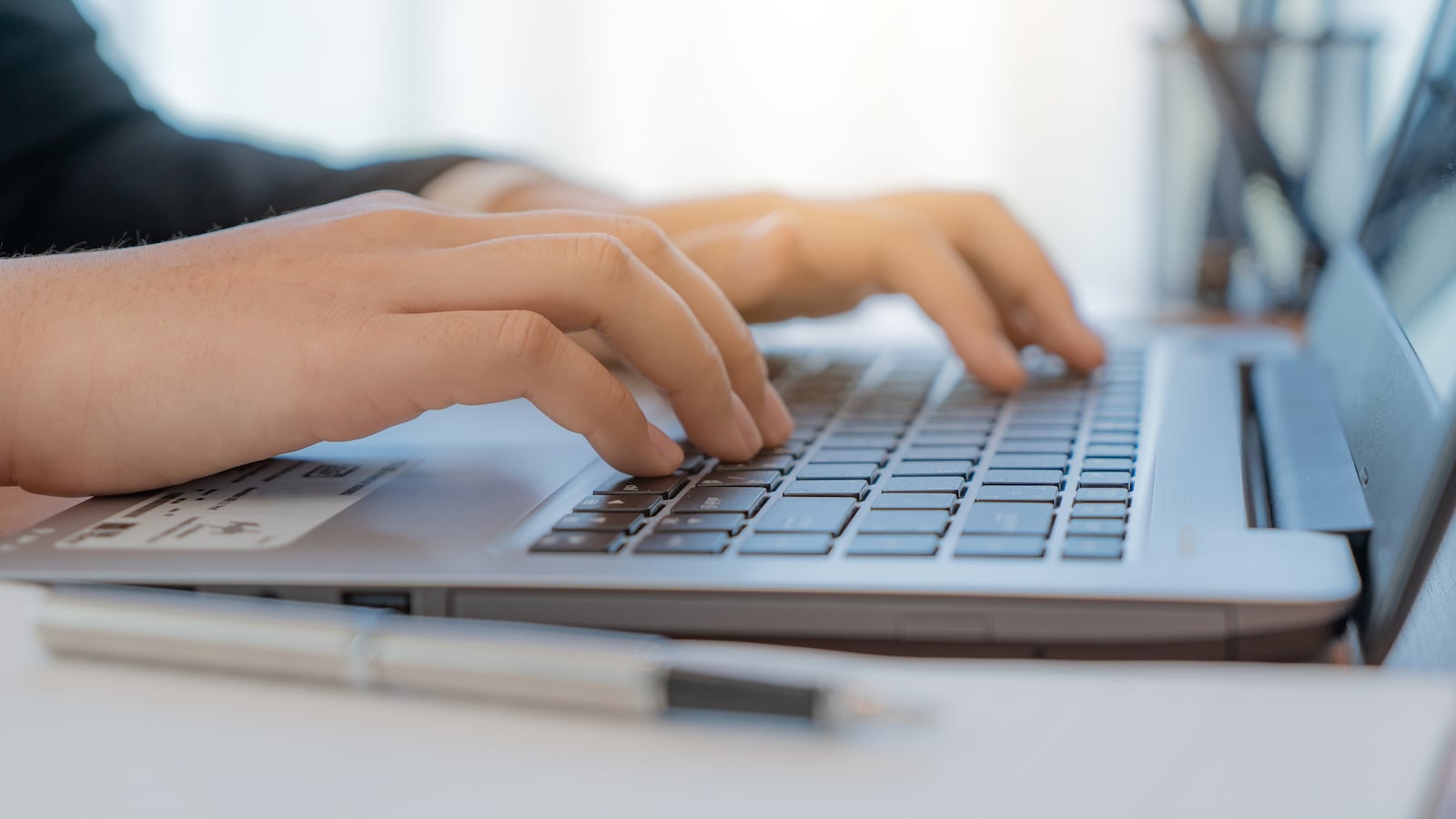 A person types on a laptop.