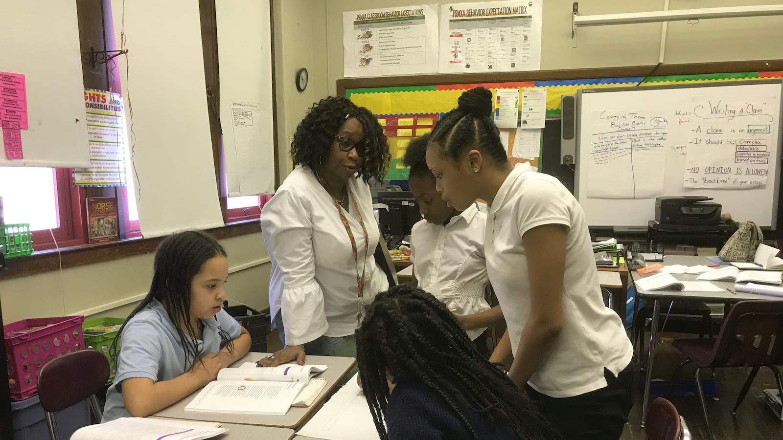 Welia Dawson, a teacher at Paul Robeson Malcolm X Academy, works with some of her sixth grade students during a class lesson.