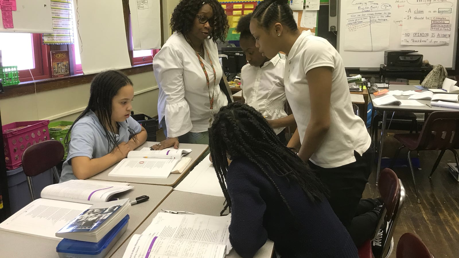 Welia Dawson, a teacher at Paul Robeson Malcolm X Academy, works with some of her sixth grade students during a class lesson.