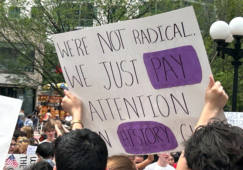 A person at a rally holds a sign.