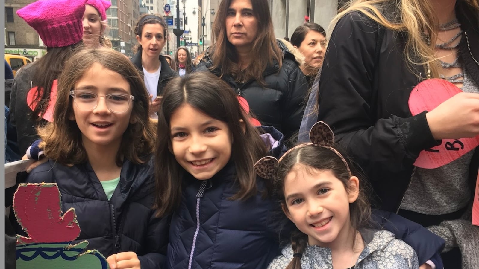Young children attending a Women's March and are holding signs.
