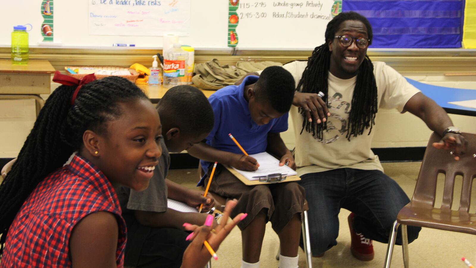 Freedom School teacher Lozie Guy (right) walks his class through an exercise where they build their own family trees during the summer learning program at Frayser Achievement Elementary School in Memphis.