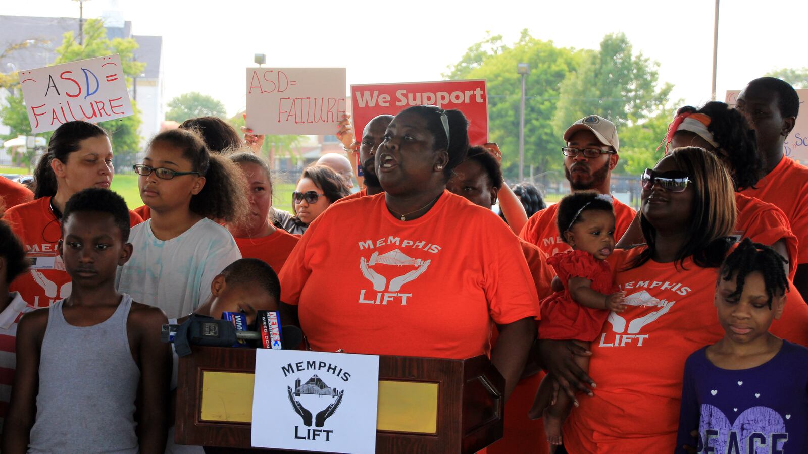Memphis Lift advocates talk about their mission in 2015 against the backdrop of signs protesting the state’s Achievement School District.