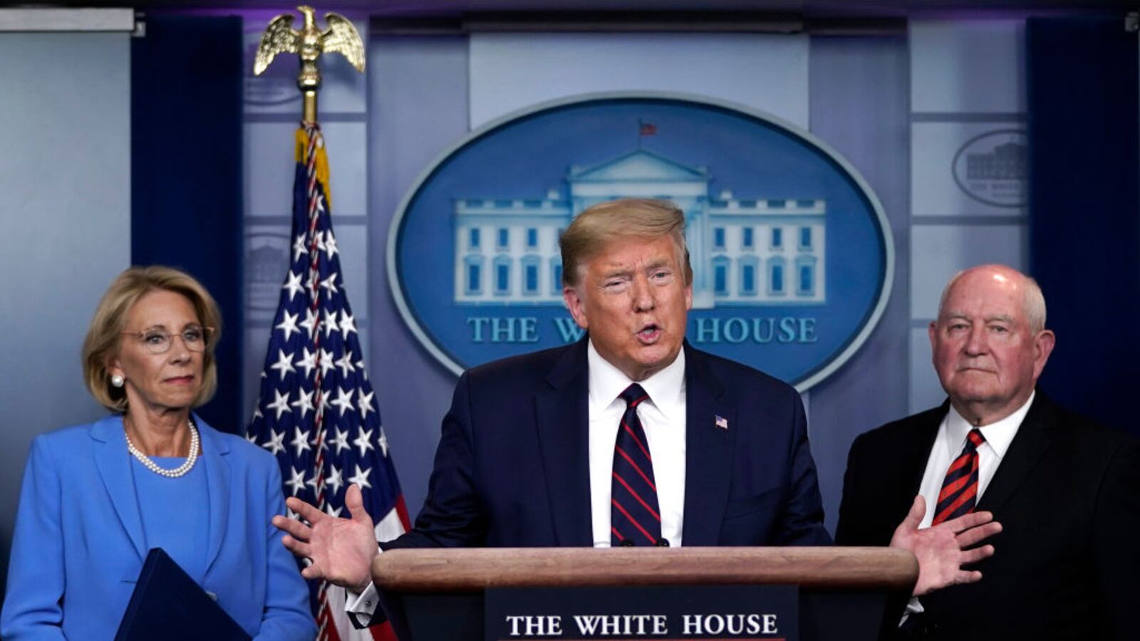 U.S. President Donald Trump has Secretary of Education Betsy DeVos and Secretary of Agriculture Sonny Perdue look on during a briefing on the coronavirus pandemic in the press briefing room of the White House on March 27, 2020 in Washington, DC. (Photo by Drew Angerer/Getty Images)