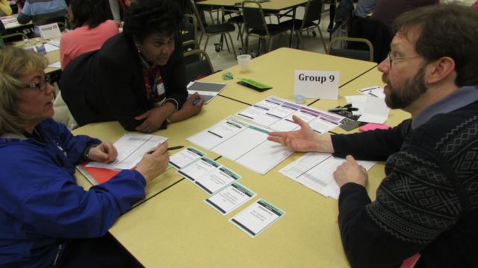 School 43 physical education teacher Lori Harting (left), School 114 social worker Perle Washington (center) and alternative school teacher Walter Nordstrom (right) discuss options for their compensation plan proposal. (Scott Elliott)