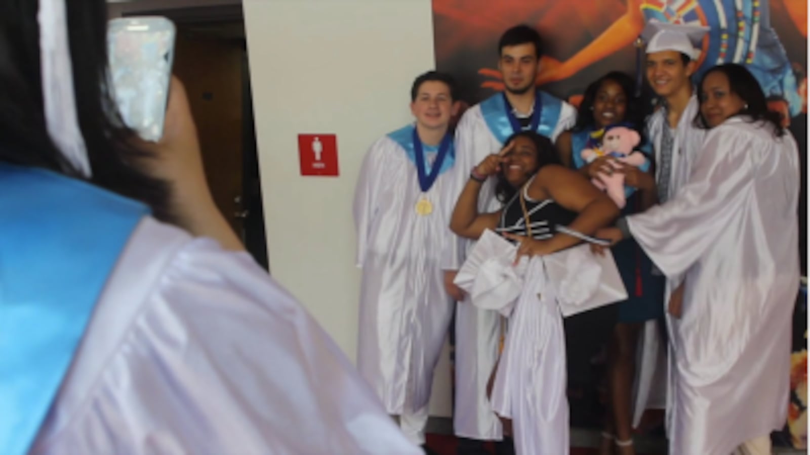 Students take photos before graduating from the closing Christopher Columbus High School.