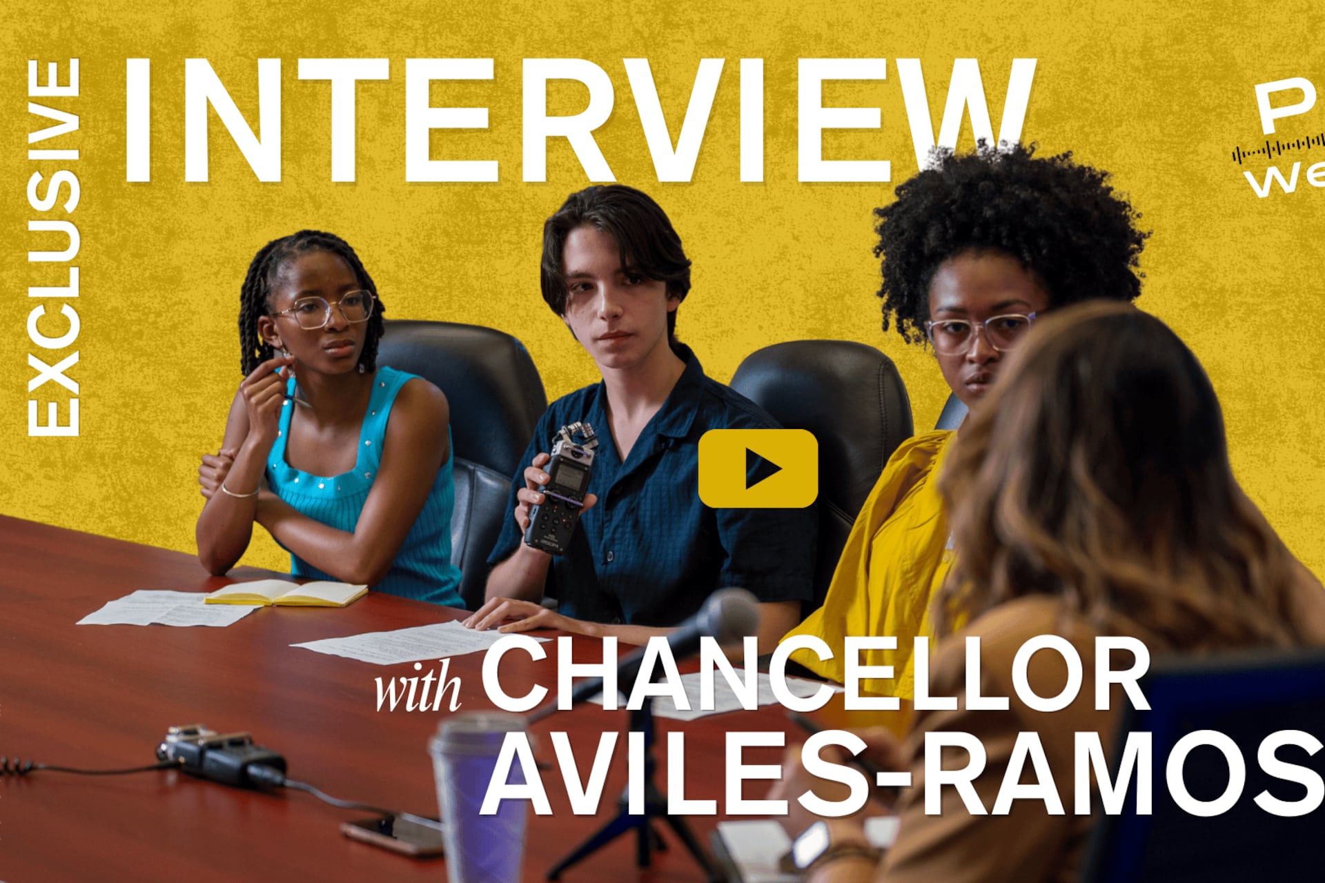 Three high school students sit at a wood table with a woman facing them.