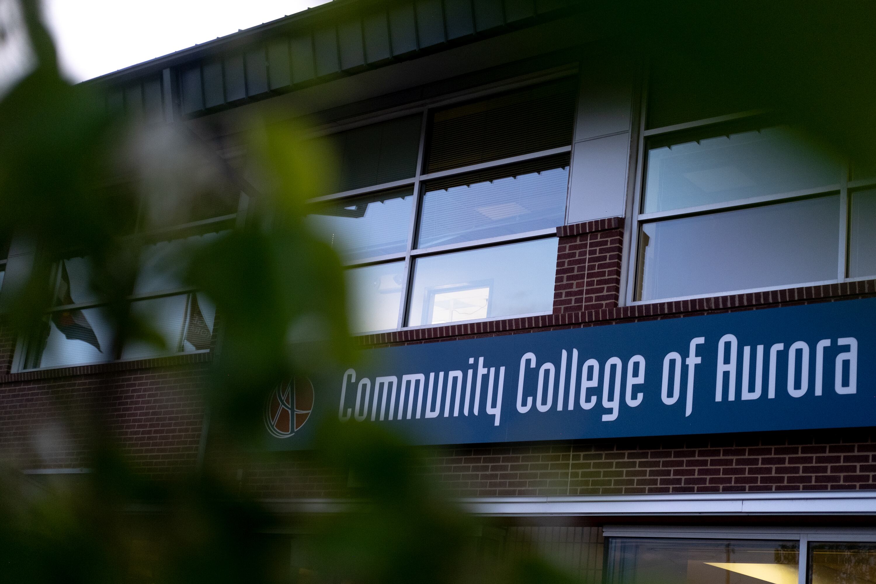 "Community College of Aurora" is seen on the side of a building.